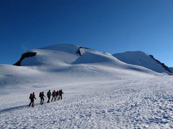 ザイルを繋いで氷河帯を渡る登山パーティ